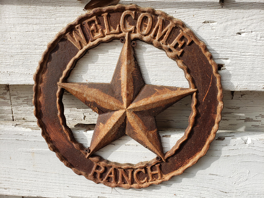a rusty star-shaped sign stating 'welcome to the ranch'