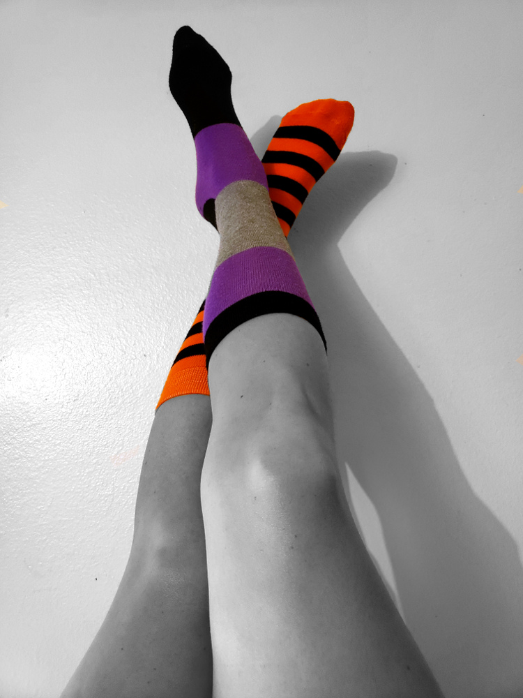 a pair of legs wearing differently colored thigh-high socks