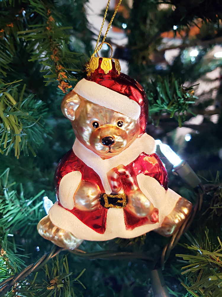 a Santa teddy bear ornament in a Christmas tree