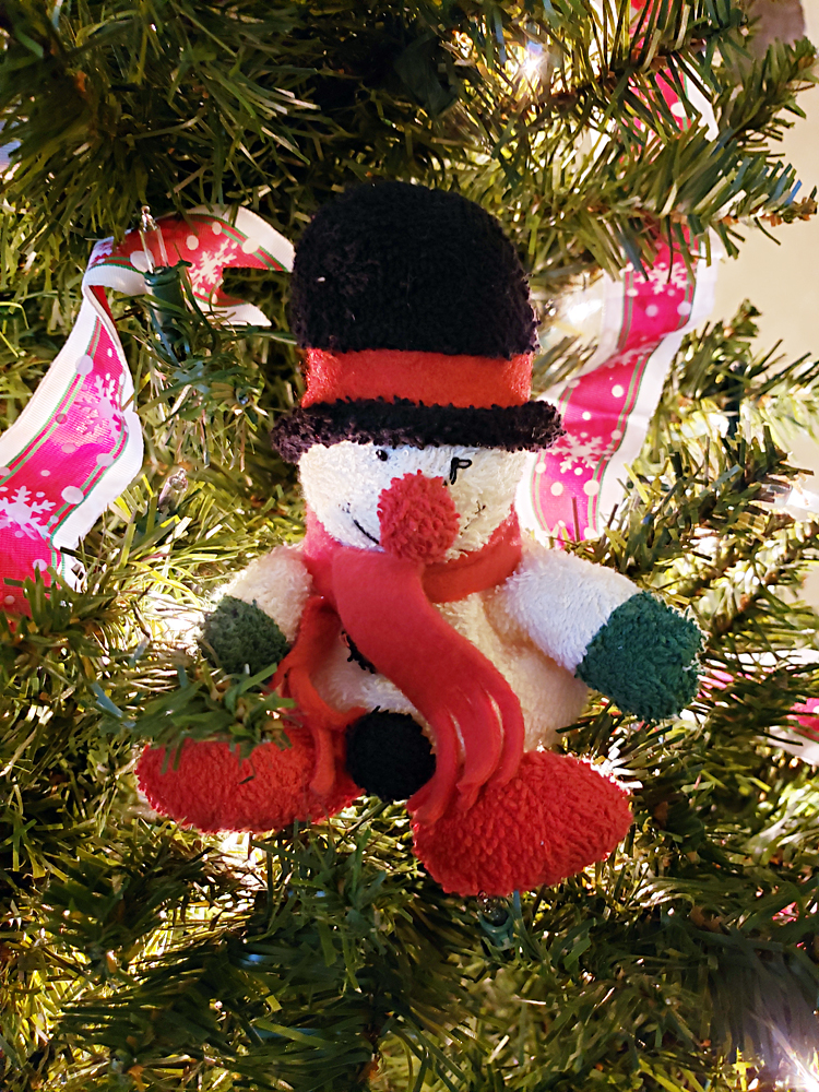 a yarn snowman ornament in a Christmas tree