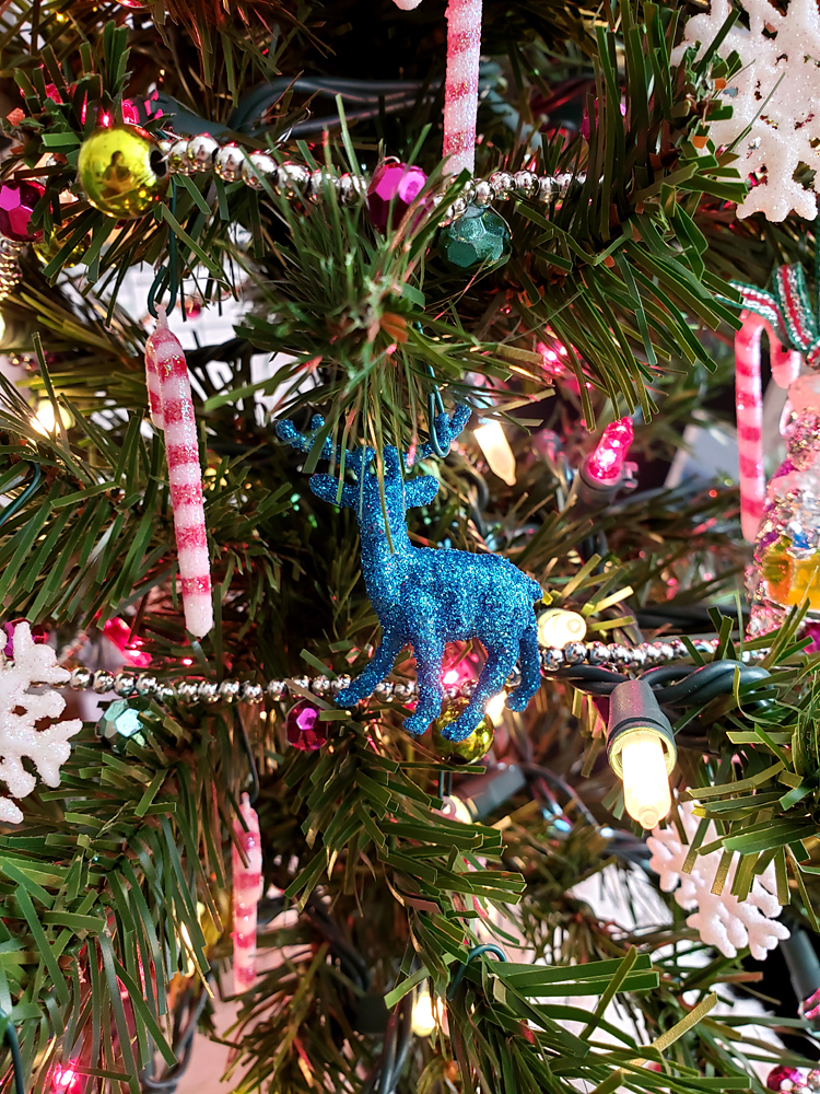 A glittery reindeer ornament in a Christmas tree