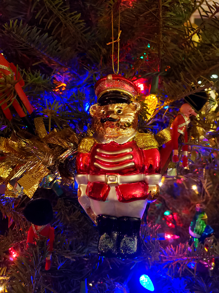 A nutcracker styled bear oranment in a Christmas tree