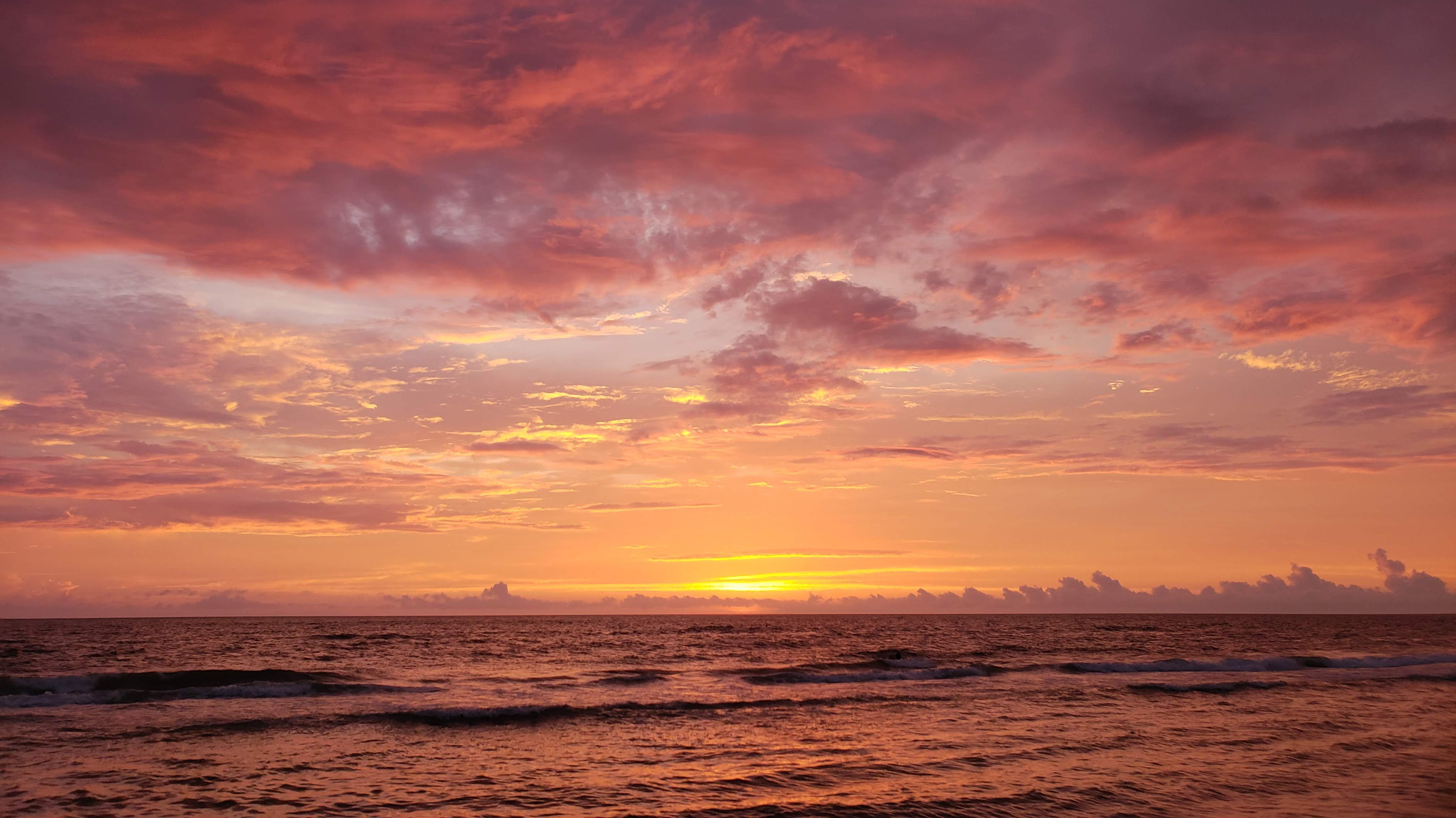 a brilliant pink and orange sunset on a Florida beach