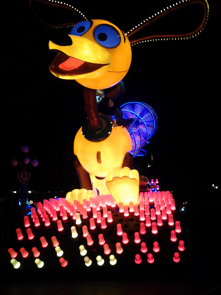 a lit-up Disney float featuring a larger-than-life Slinky Dog from Toy Story