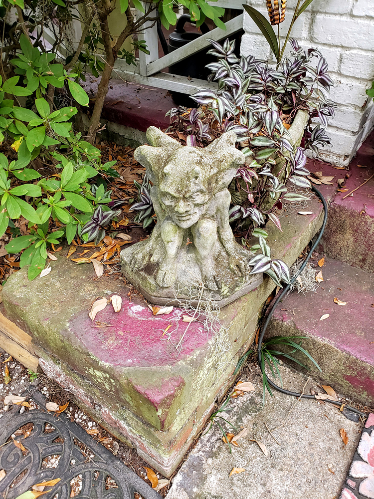 a small concrete gargoyle on the front porch of a house
