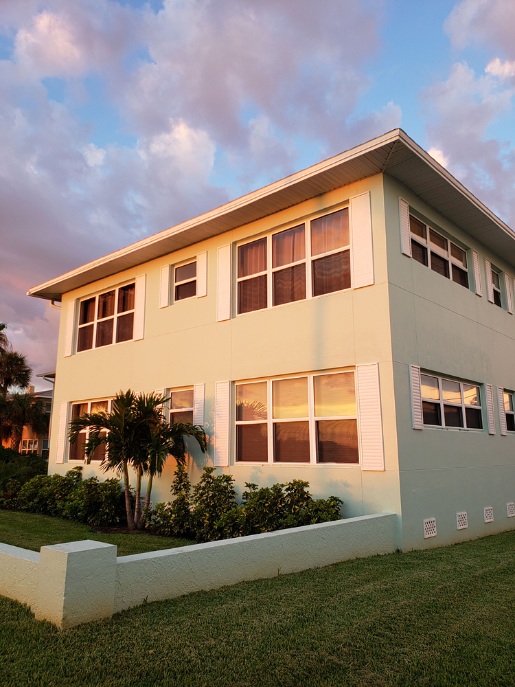a pastel condominium reflecting the colors of a beach sunset, almost too perfect to be real