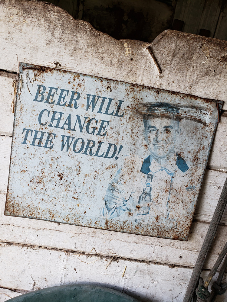 a rusting sign declaring 'beer will change the world!'