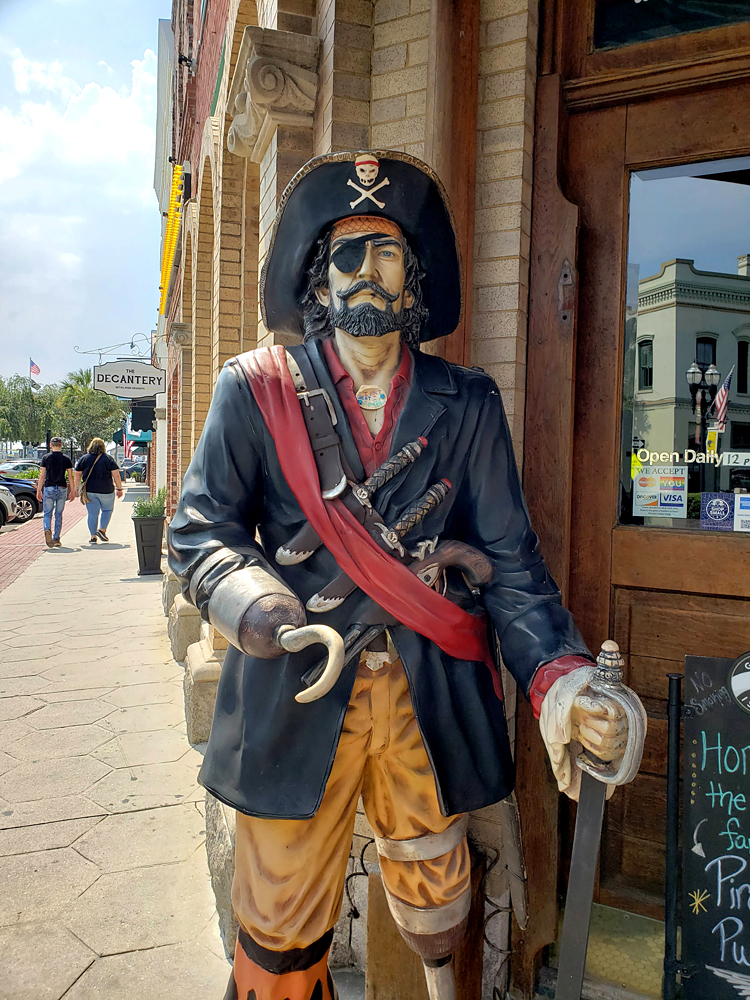 a colorful life-size pirate statue in front of a bar